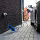 Voldt® Type 1 Portable Charger plugged into an outdoor wall socket next to a car